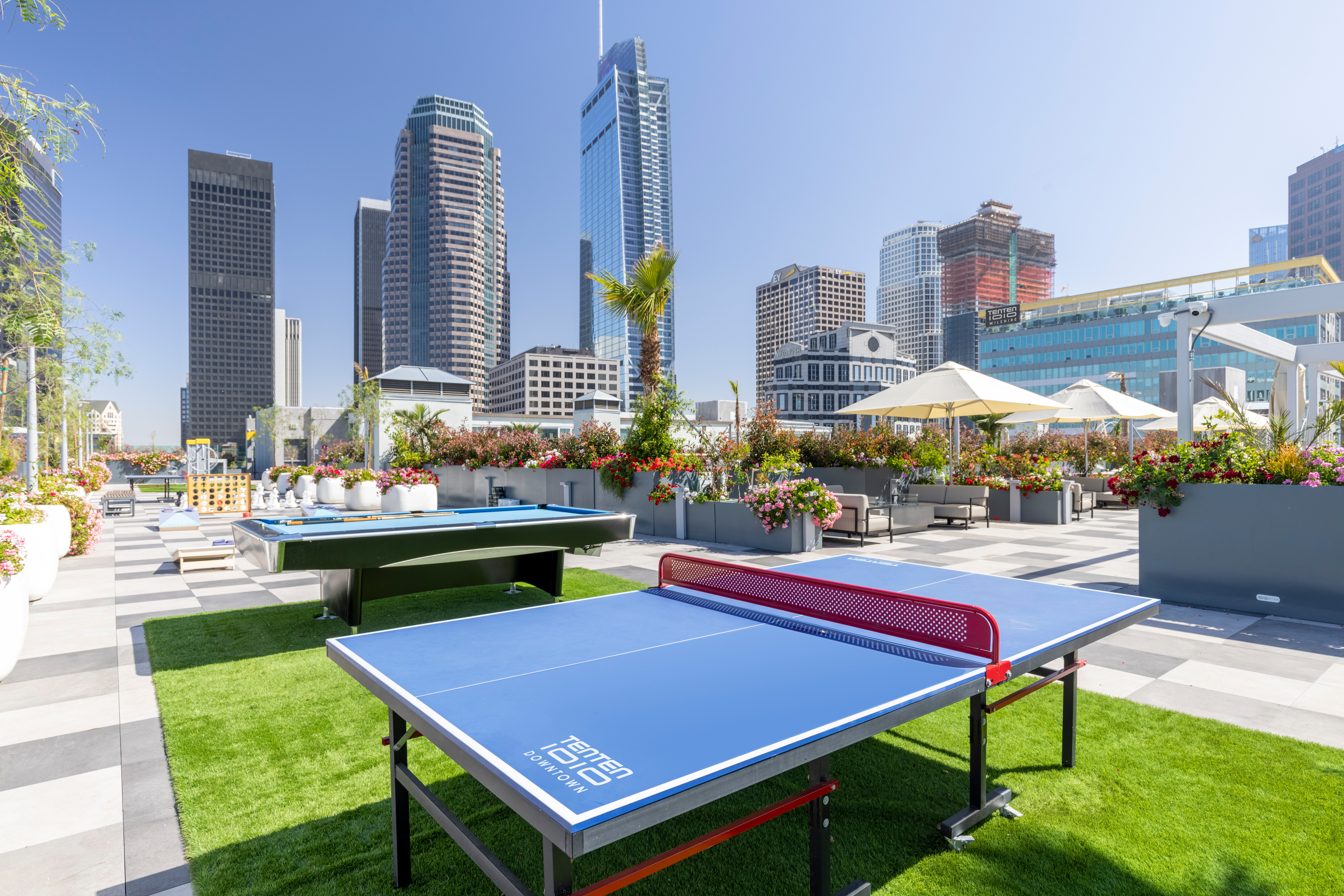 outdoor recreational area with ping pong foosball, and connect four games on a grassy rooftop.