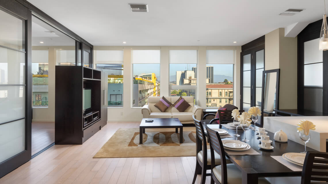Lounge room with dining table and window view towards a city