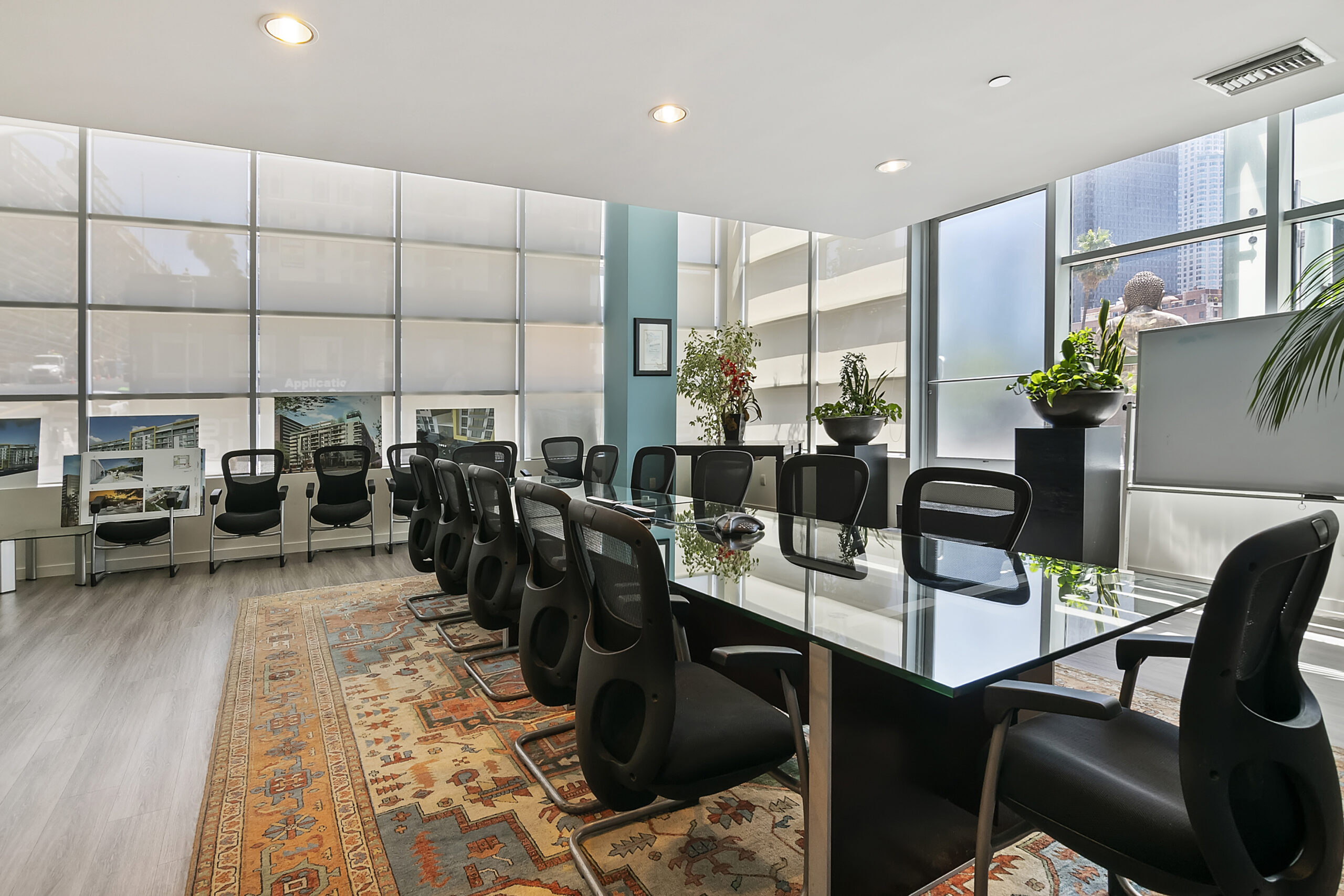 large meeting area with a long table and a dozen black chairs